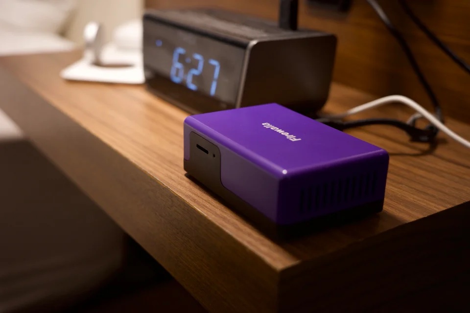 Firewalla Purple placed on a hotel nightstand